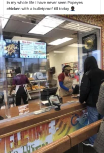 A woman stands at a fast food counter, possibly at Popeyes, with a focused expression, surrounded by restaurant decor.
